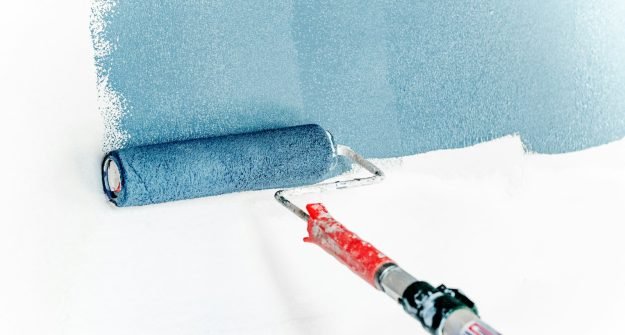 Paint roller applying a fresh coat to a wall
