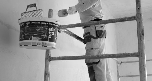 Painter rolling paint onto an interior wall during a property maintenance job in Belfast
