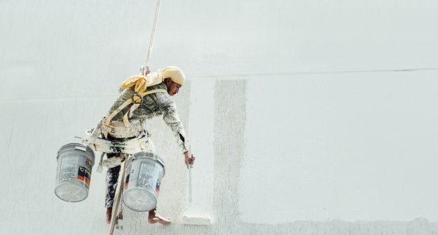Painter finishing a white wall